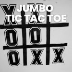jumbo tic tac toe board and pieces on dry erase board in classroom 