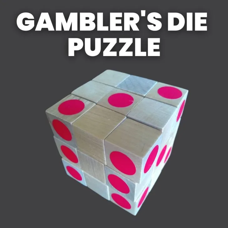 wooden cubes arranged in a 3x3x3 cube with red stickers on some cube faces with text "gambler's die puzzle" 