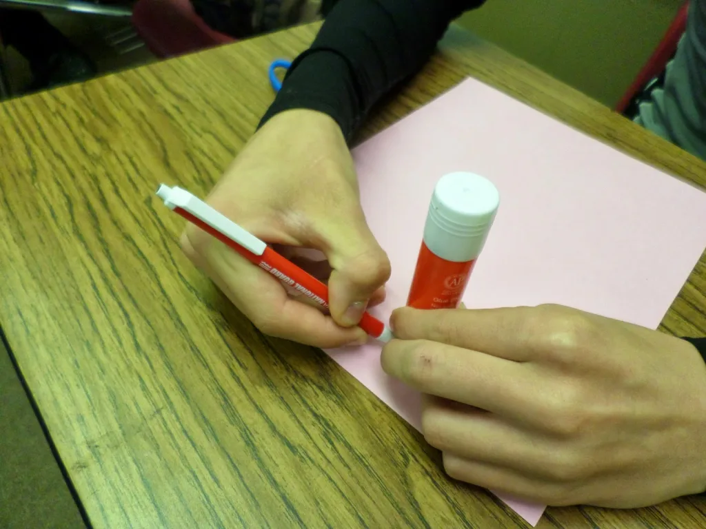 student tracing glue stick for Cutting Pi Discovery Activity.  
