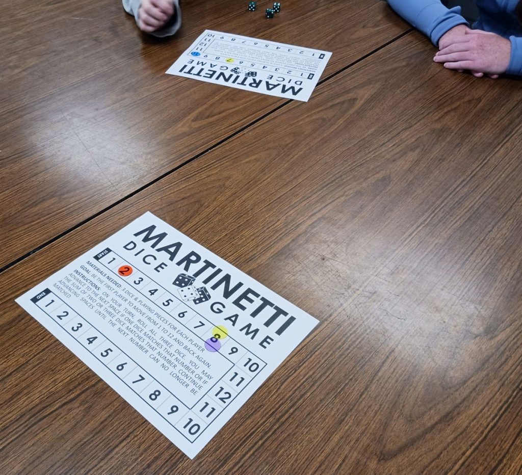 two groups of students playing martinetti dice game 