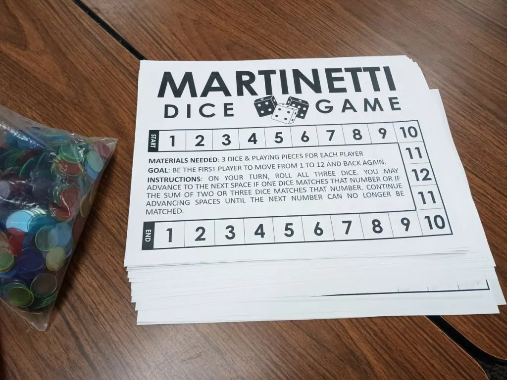 pile of martinetti dice game boards next to bag of bingo chips 