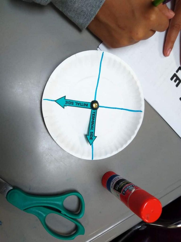 paper plate angle spinner sitting on student desk next to gluestick and scissors 