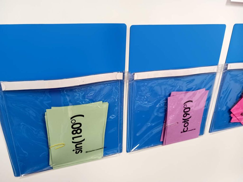 close-up of odd one out cards in magnetic pouches on dry erase board 