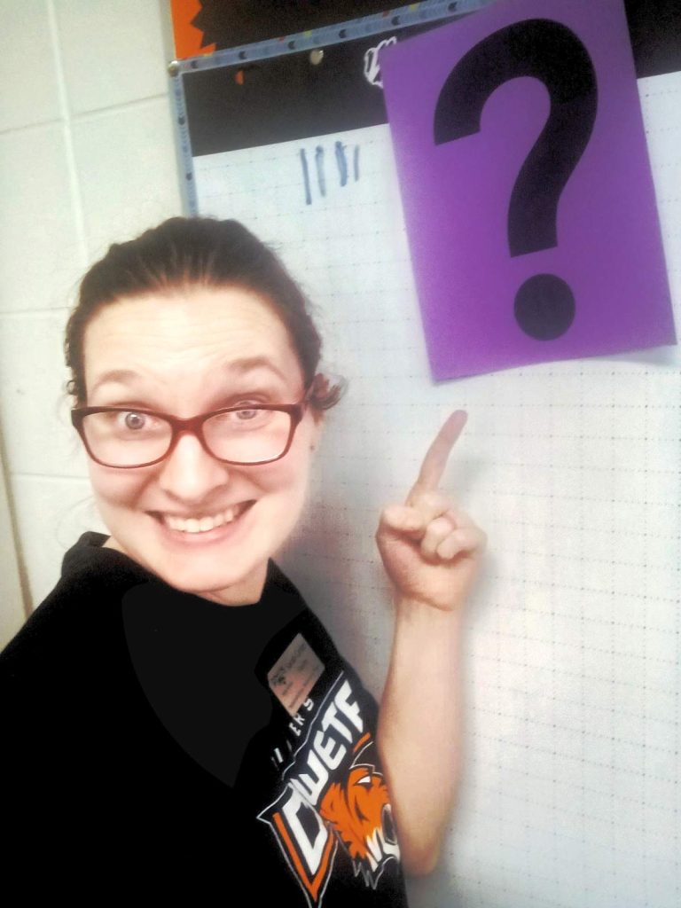 sarah carter pointing to question mark poster for number contest 