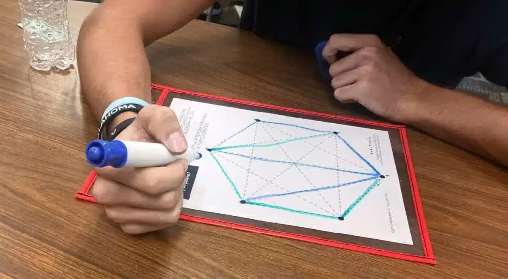 student playing game of sim in dry erase pocket 