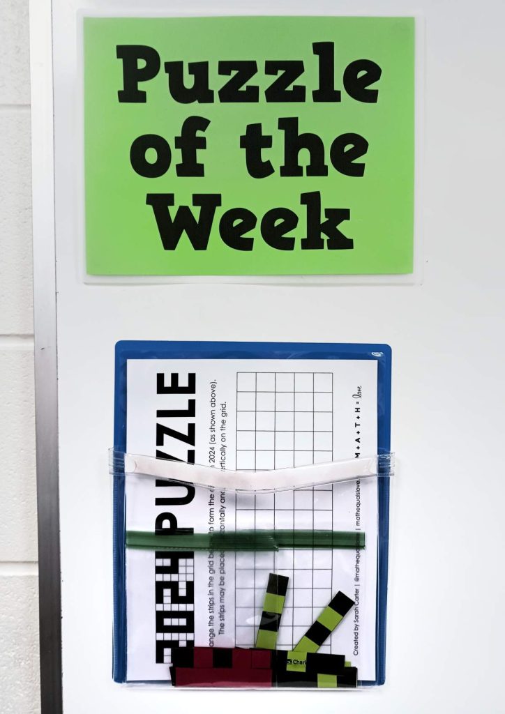 2024 puzzle hanging under sign that reads "Puzzle of the Week" 
