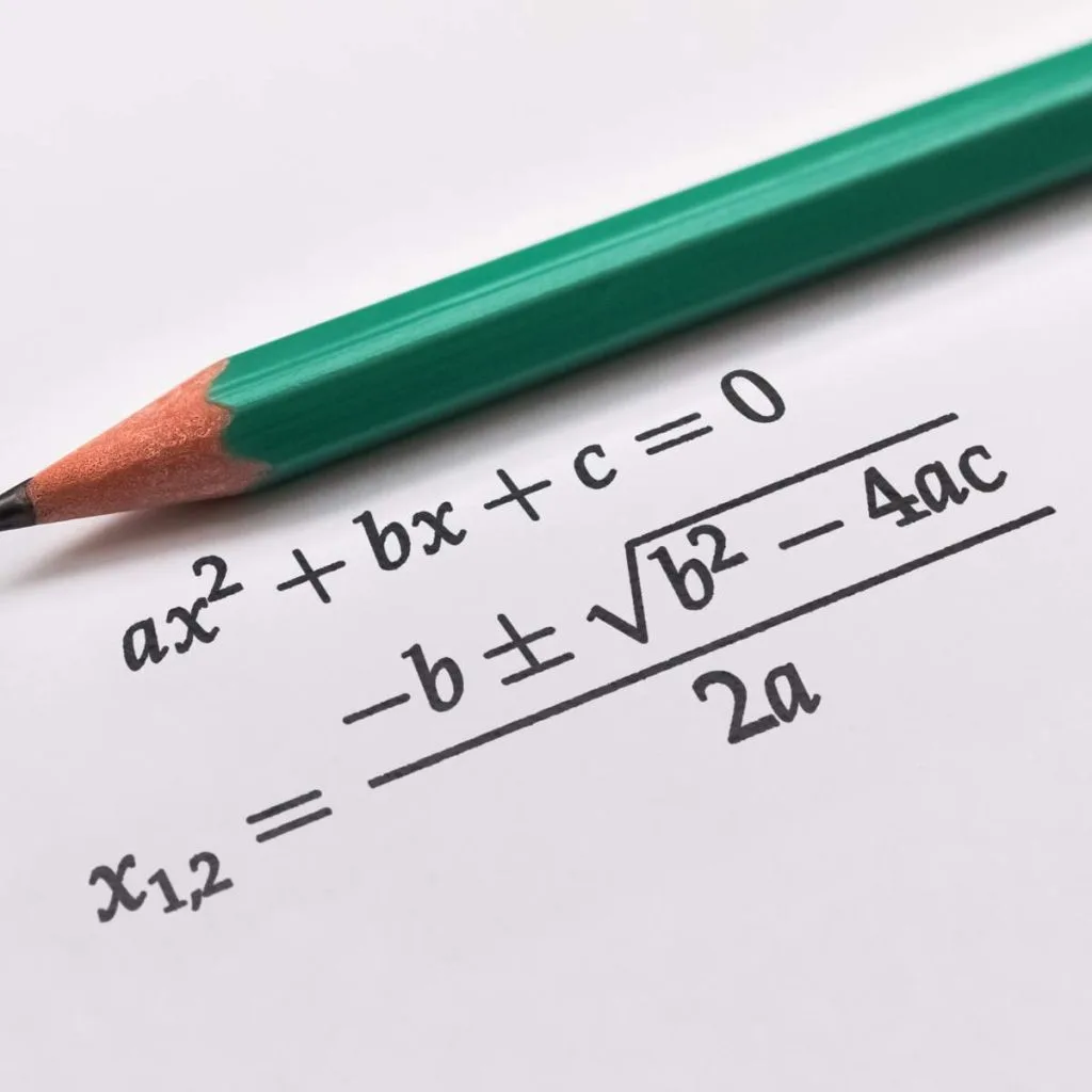 quadratic formula printed on paper with pencil laying above. 