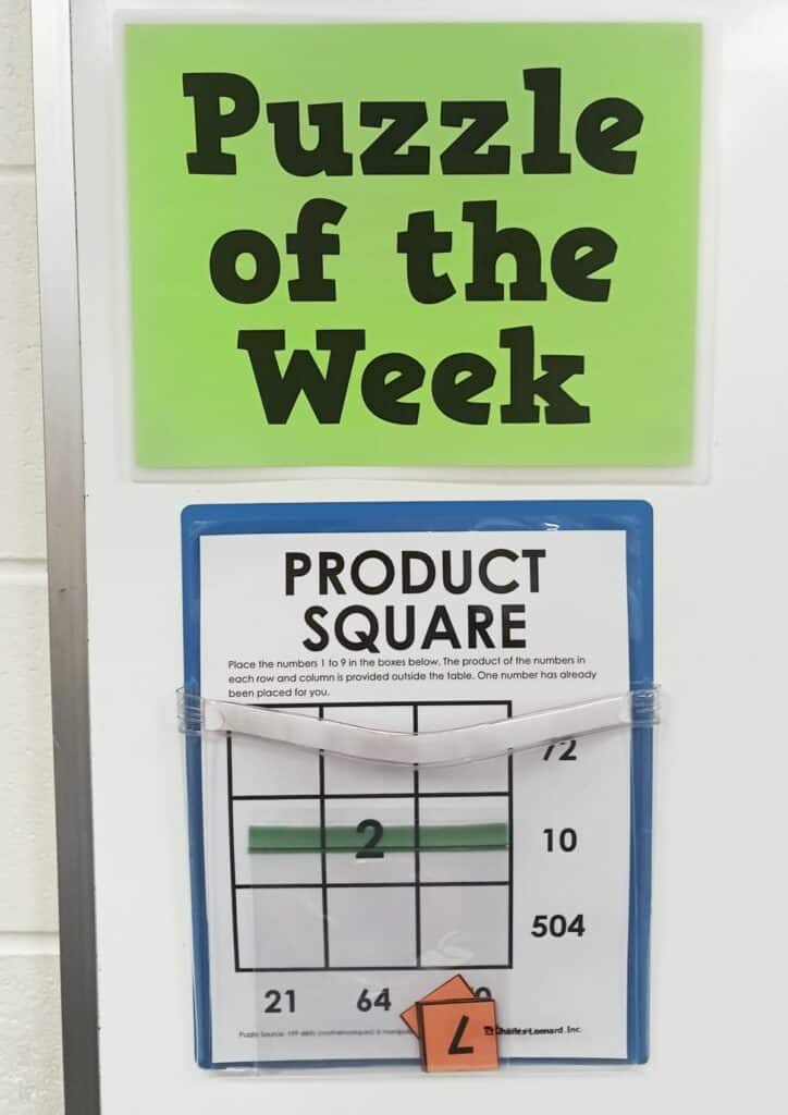 product square puzzle hanging in magnetic pocket on dry erase board under sign which reads "puzzle of the week" 