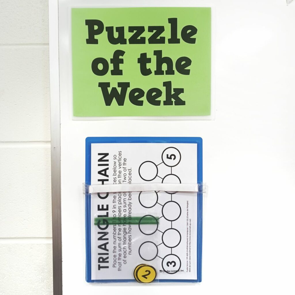 Triangle Chain Puzzle Hanging under sign reading "Puzzle of the Week" 