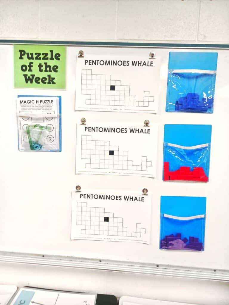 pentominoes whale puzzles hanging on dry erase board in classroom. 