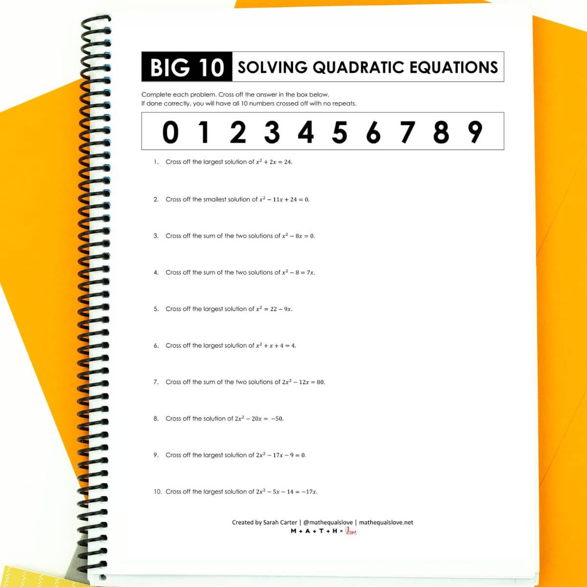 solving quadratic equations by factoring worksheet in notebook with orange paper in background.