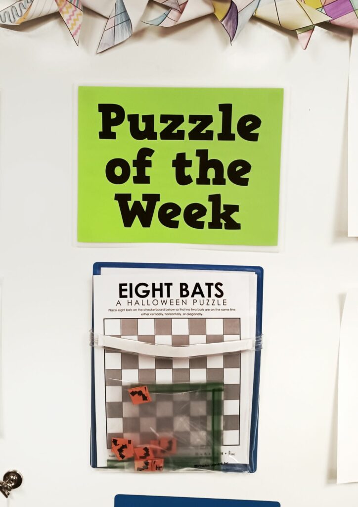 eight bats halloween puzzle hanging on dry erase board under sign which reads "puzzle of the week." 