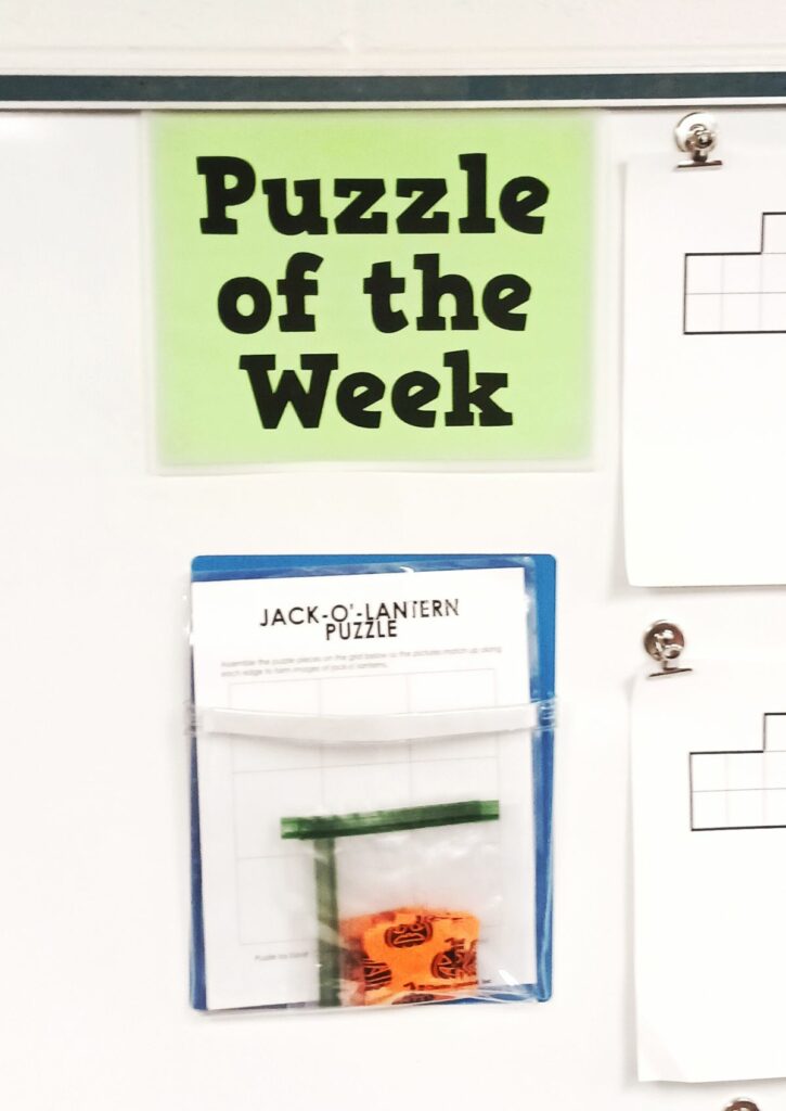 jack-o-lantern square puzzle in dry erase pocket hanging under sign which reads "puzzle of the week" 