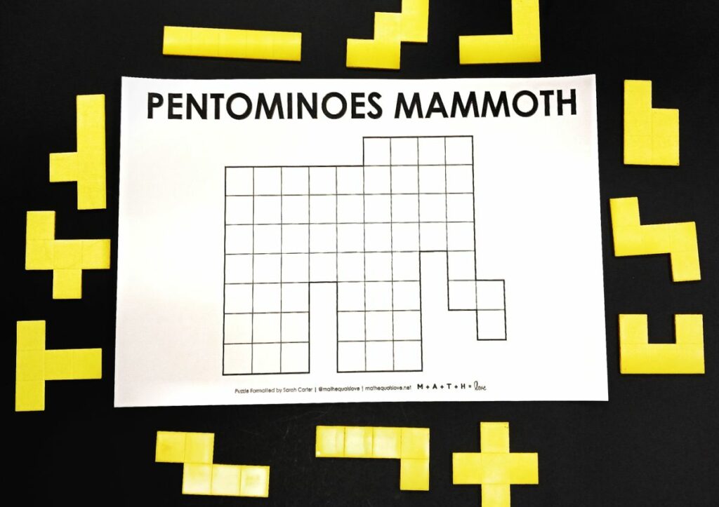 pentominoes mammoth puzzle with pentomino pieces surrounding it. 
