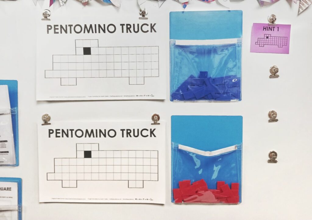 pentomino truck puzzle hanging on dry erase board. 