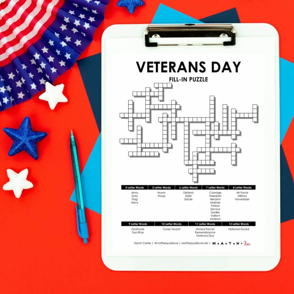 Veterans Day Fill-In word puzzle on clipboard next to patriotic decorations. 