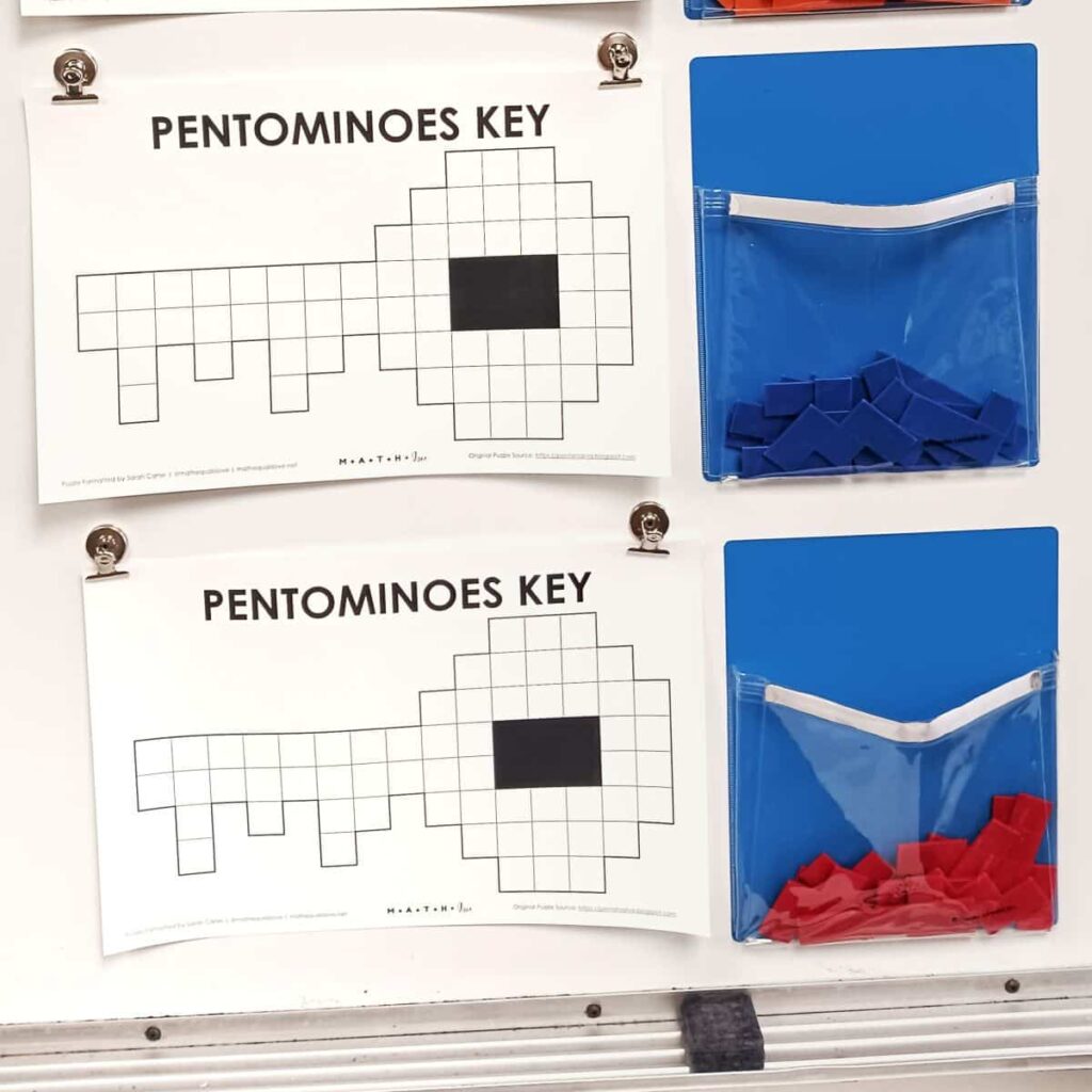 pentomino key puzzle hanging on dry erase board in classroom.