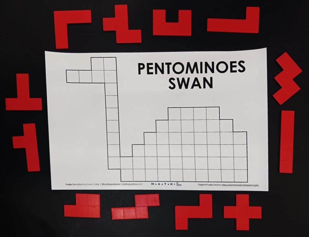 pentominoes swan puzzle with pentominoes pieces around puzzle.